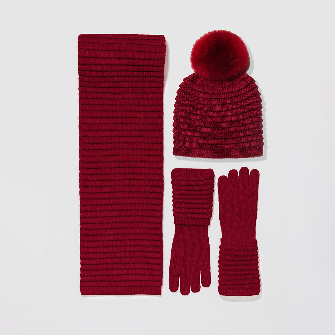 Sentaler Adult Ribbed Garnet Red Hat with Oversized Fur Pompon, Ribbed Garnet Red Scarves, Ribbed Garnet Red Gloves flat lay.