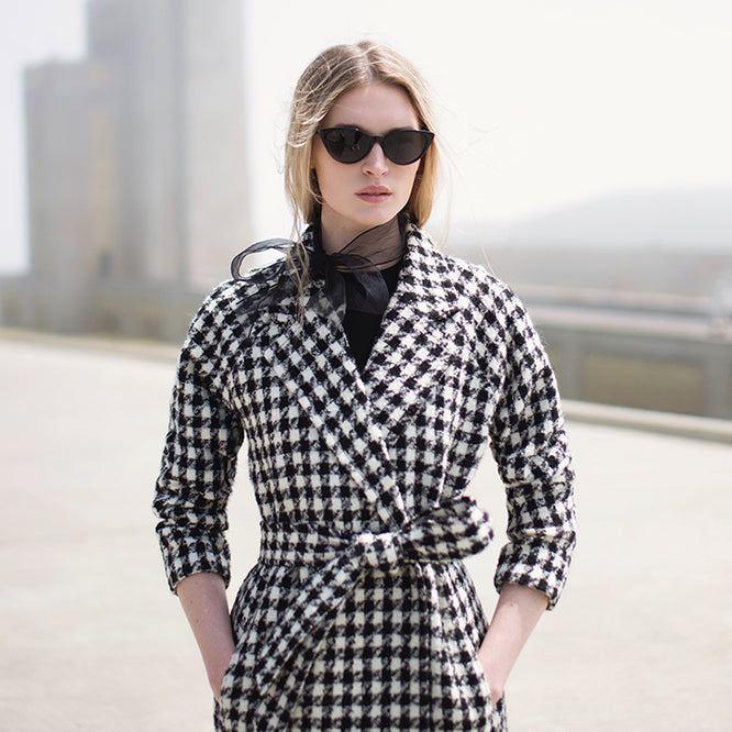 Sentaler Black and White Houndstooth Tweed Suri Alpaca Long Raglan Sleeve Wrap Coat on model, city landscape in background.